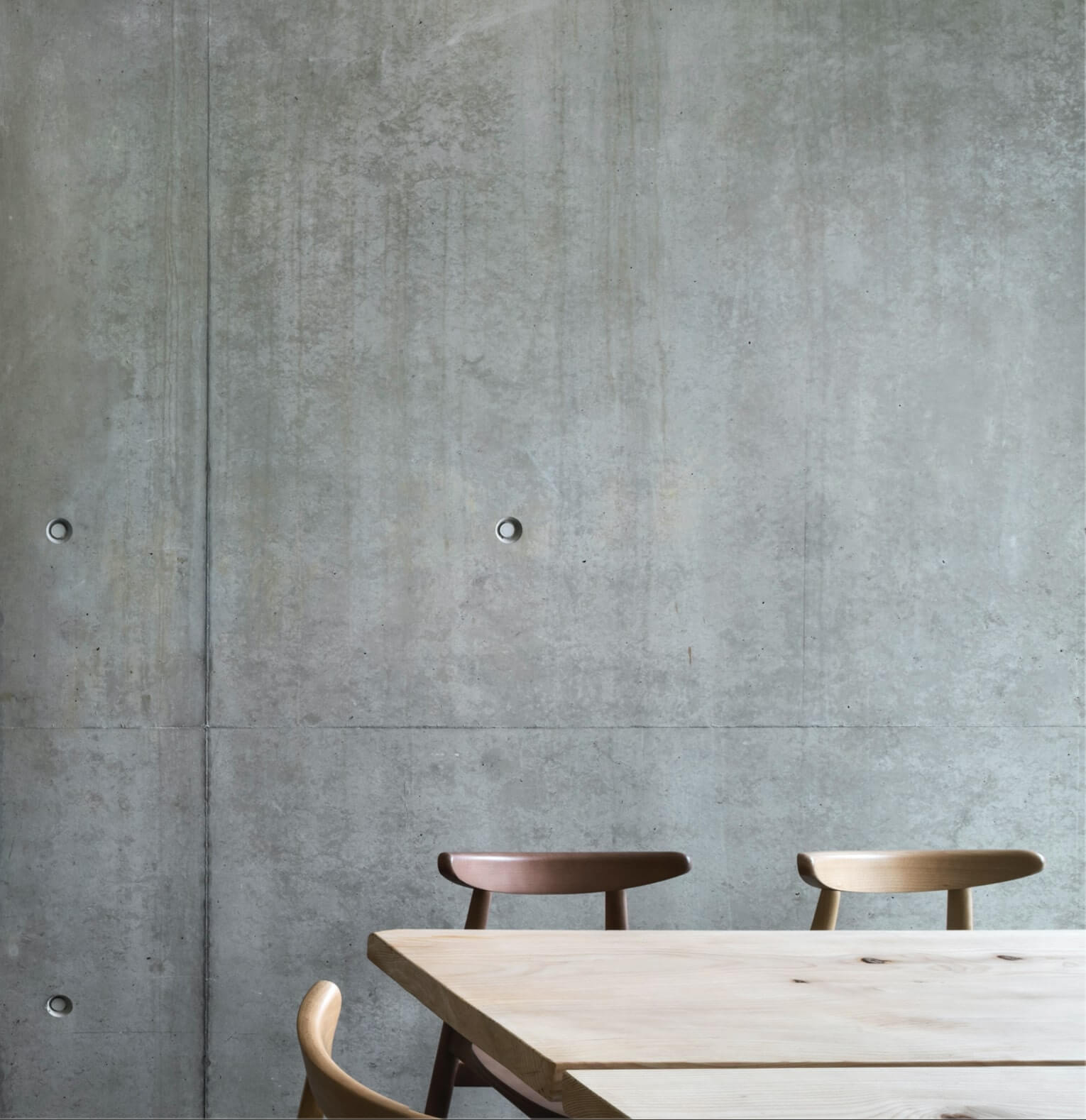 the wooden table and chairs are in front of a concret interior